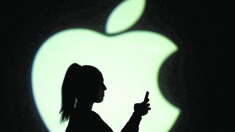 FILE PHOTO: Silhouette of mobile user is seen next to a screen projection of Apple logo in this picture illustration taken March 28, 2018.  REUTERS/Dado Ruvic/Illustration/File Photo-NARCH/NARCH30 NARCH/NARCH30