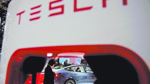 FILE PHOTO: A Tesla electric vehicle is seen through a charging point displayed during a media day for the Auto Shanghai show in Shanghai, China April 20, 2021. REUTERS/Aly Song/File Photo/File Photo-NARCH/NARCH30 NARCH/NARCH30 NARCH/NARCH30 NARCH/NARCH30