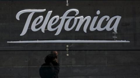 A reflection of a man talking on his phone is seen outside Telefonica's flagship store in central Madrid, Spain, April 28, 2015. Telefonica's move to hike prices in Spain is a bold bet that could finally draw a line under a six-year slump, cut the firm's reliance on Latin America and give it a leg up over rivals on the lucrative premium telecoms market, sources and analysts say. The telecoms giant, whose revenues have dropped 13 percent worldwide and 42 percent in Spain since 2008, has focused on fewer markets, cut debt and invested in new high-speed networks and exclusive television contents to try and regain its mojo. Picture taken on April 28, 2015.  To match story TELEFONICA-SPAIN/PRICES      REUTERS/Sergio Perez