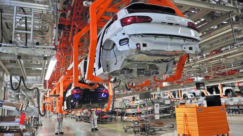 Employees work at an Audi Q5 2.0 production line of the German car manufacturer