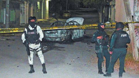 Federal forces keep watch at the scene of an overnight car blast in Celaya