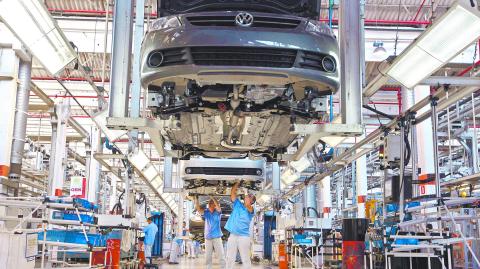 Brazilian workers assemble a Volkswagen car at Sao Bernardo do Campo Volkswagen plant, near Sao Paulo April 6, 2011. Automobile production in Brazil, Latin America's largest economy, probably rose again March as manufacturers look to keep up with surging demand. Sales of new cars and light trucks have been soaring in Brazil over the past year, benefiting from a red-hot economy and a credit boom that is allowing many Brazilians to buy cars for the first time. REUTERS/Nacho Doce (BRAZIL - Tags: TRANSPORT BUSINESS)