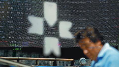 FILE PHOTO: An employee is pictured behind the logo of the Mexican stock exchange in in Mexico City