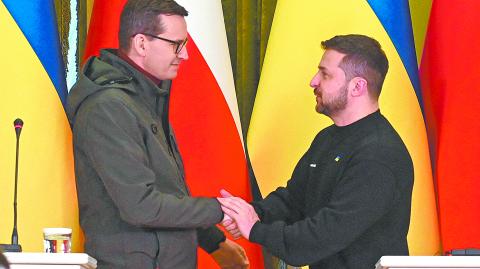 El presidente de Ucrania Volodímir Zelenski saluda al primer ministro de Polonia Mateusz Morawiecki en imagen del 24 de febrero en Kyiv. Foto: Reuters