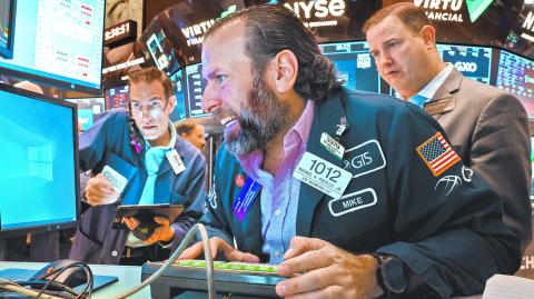 Traders work on the floor of the NYSE in New York