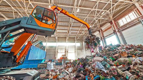 Excavator,Grabs,Trash,In,Warehouse,Of,Waste,Processing,Plant