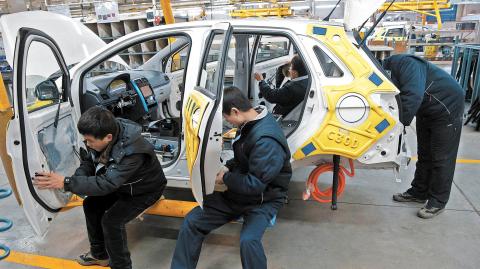 Employees work on an assembly line producing electronic cars at a factory of Beijing Electric Vehicle, funded by BAIC Group, in Beijing, China, January 18, 2016.REUTERS/Kim Kyung-Hoon