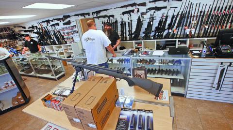 Prospective buyers look at guns at the "Ready Gunner" gun store In Provo