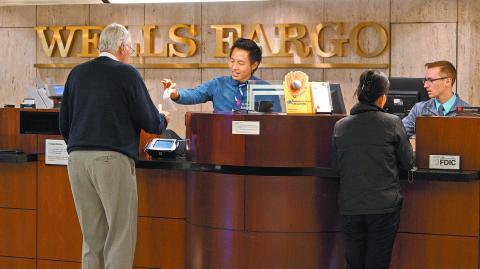 FILE PHOTO: Tellers serve customers at the Wells Fargo & Co. bank in downtown Denver