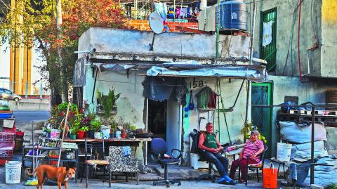 A couple is photographed in front of their house in the La Boca neighborhood in Buenos Aires on September 20, 2024. (Photo by LUIS ROBAYO / AFP)