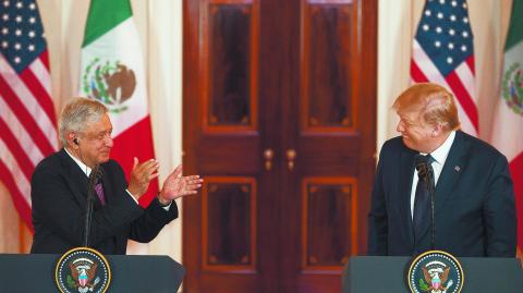 US President Donald Trump smiles as Mexican President Andres Manuel Lopez Obrador applauds him as they speak before a working dinner the White House on July 8, 2020, in Washington, DC. (Photo by JIM WATSON / AFP)