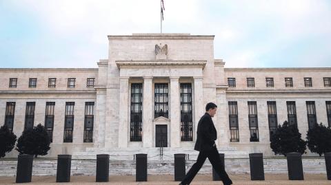 FILE PHOTO: A man walks past the Federal Reserve in Washington, December 16, 2015. The U.S. central bank is widely expected on Wednesday to hike its key federal funds rate by a modest 0.25 percent. It would be the first tightening in more than nine years and a big step on the tricky path of returning monetary policy to a more normal footing after aggressive bond-buying and near-zero borrowing costs. REUTERS/Kevin Lamarque/File Photo