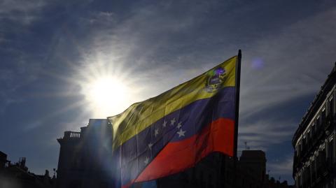 Los manifestantes ondean banderas venezolanas durante una marcha después de un llamado a protestas globales contra los resultados de las disputadas elecciones en Venezuela.