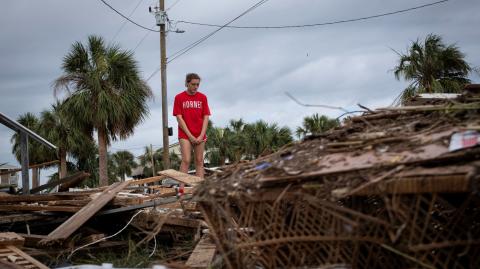 Piper Wagenman se encuentra entre los escombros de la casa de playa de su familia, luego del huracán Helene en Horseshoe Beach, Florida.