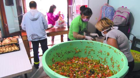 Volunteers prepare food at a community kitchen of the MRP (Movimiento Resistencia Popular) during the lockdown imposed by the government against the spread of the new coronavirus, COVID-19, at La Boca neighborhood in Buenos Aires, Argentina, on April 22, 2020. (Photo by JUAN MABROMATA / AFP)