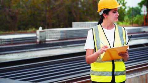 Portrait Hispanic latin engineer woman use clipboard checking precast cement at precast cement outdoor factory