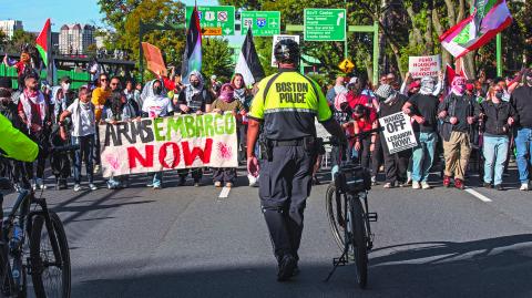 Police look on as pro-Palestinian demonstrators march during a rally to mark one year of the war between Hamas and Israel in Boston, Massachusetts on October 6, 2024. (Photo by Joseph Prezioso / AFP)