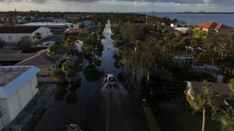 La vista de un dron muestra un automóvil conduciendo por una calle inundada después de que el huracán Milton tocara tierra en South Daytona, Florida.