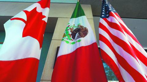 (FILES) This file photo taken on September 24, 2017 shows the Mexican, US and  Canadian flags in the lobby where the third round of the NAFTA renegotiations took place in Ottawa, Ontario.
Canada announced on January 23, 2018 it will sign on the Trans Pacific Partnership, moving to diversify its trade relationships  as Canadian, US and Mexican negotiators kicked off a sixth round of talks on a 1994 free trade pact that Washington has threatened to dump. Canada had initially balked at joining the proposed TPP last year, acting as the main holdout in negotiations after US President Donald Trump decided in early 2017 to go it alone under his "America First" policy.
 / AFP PHOTO / Lars Hagberg