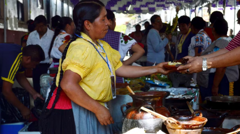 Mujer sirviendo corundas en el Tianguis de Domingo de Ramos en Uruapan, Michoacán, México.