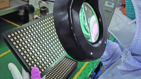 FILE PHOTO: A worker inspects semiconductor chips at the chip packaging firm Unisem (M) Berhad plant in Ipoh, Malaysia October 15, 2021. REUTERS/Lim Huey Teng/File Photo