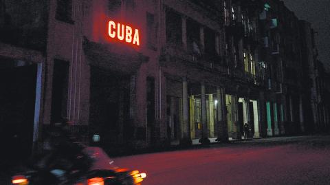 A sign lits a blacked out street during the second day of the nationwide blackout in Havana October 19, 2024. - Hurricane Oscar is due to hit the island of Cuba imminently, with the risk of further affecting the population, who are spending their second night without electricity due to a giant blackout. (Photo by ADALBERTO ROQUE / AFP)