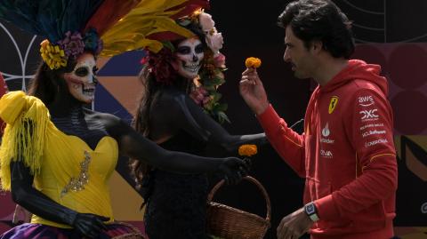 El piloto español Carlos Sainz Jr. recibe una flor de cempasúchil de manos de mujeres vestidas como las tradicionales "Catrinas" a su llegada al autódromo Hermanos Rodríguez.