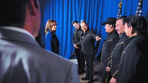 US Vice President Kamala Harris (L) meets with members of Norteno band Los Tigres del Norte before speaking during a campaign rally at Talking Stick Resort Amphitheatre in Phoenix, Arizona, on October 31, 2024. (Photo by Brendan Smialowski / AFP)