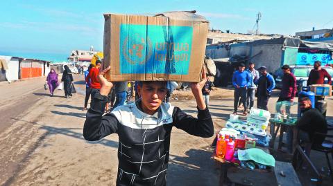 Un palestino carga una caja distribuida por la UNRWA, en medio del conflicto entre Israel y Hamás. Imagen del 4 de noviembre.