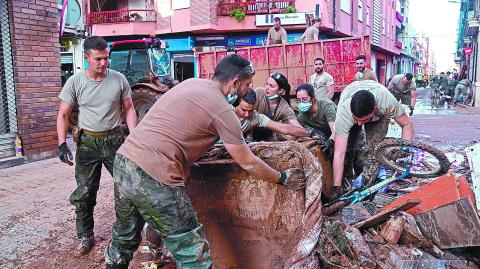 Spanish soldiers remove debris in Sedavi, south of Valencia, eastern Spain, on November 5, 2024 following devastating flooding. - Spain announced an aid package worth 10.6 billion euros ($11.5 billion) to rebuild regions devastated by its worst floods in a generation that have killed 219 people. (Photo by JOSE JORDAN / AFP)