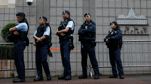 La policía hace guardia frente al edificio de los Tribunales de Magistrados de West Kowloon, antes de la sentencia contra los 45 activistas prodemocracia condenados acusados ​​en virtud de la ley de seguridad nacional, en Hong Kong.