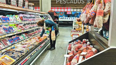 A woman buys charcuterie at a supermarket in Buenos Aires on May 23, 2024. - Argentina's economic activity continued to plummet in March, with the construction and manufacturing industries leading the slowdown as President Javier Milei's government slashes spending, official figures showed Wednesday. (Photo by STRINGER / AFP)