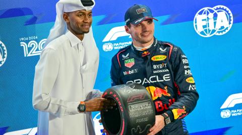 El piloto holandés de Red Bull Racing, Max Verstappen, recibe el trofeo de la pole position de manos del atleta de atletismo de Qatar, Mutaz Essa Barshim.