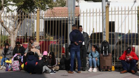 Un grupo de migrantes que buscan asilo en Estados Unidos a través de la aplicación digital CBP One esperan en fila cerca del puente internacional Paso del Norte en Ciudad Juárez, estado de Chihuahua, México.