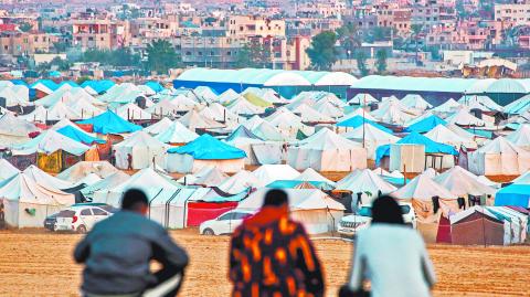 Hombres contemplan tiendas de campaña que albergan a los palestinos desplazados por el conflicto en el norte de Gaza. Foto: AFP