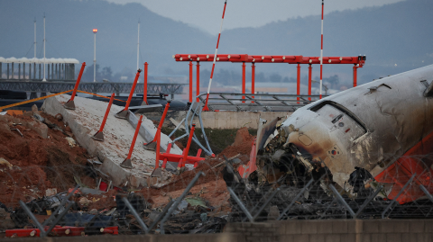 Los restos del avión de Jeju Air que se salió de la pista y se estrelló el 30 de diciembre de 2024 en el Aeropuerto Internacional de Muan se encuentran cerca de una estructura de concreto contra la que se estrelló, en Muan, Corea del Sur.