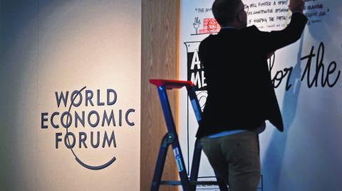 A man install a board a the Congress Center during the World Economic Forum (WEF) annual meeting in the Alpine resort of Davos on January 20, 2025. (Photo by Fabrice COFFRINI / AFP)