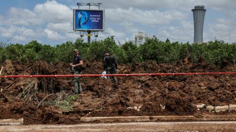 Oficiales de policía israelíes investigan un cráter en el lugar de un ataque con misiles, lanzado desde Yemen, cerca del aeropuerto Ben Gurion, en Tel Aviv , Israel.