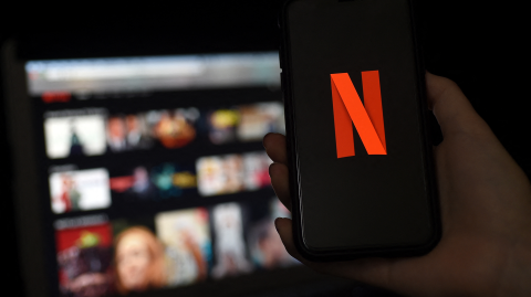 Netflix logo móvil y plataforma en pantalla.