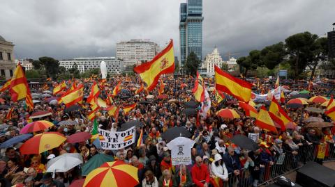 Manifestantes sostienen banderas de España durante una protesta antigubernamental convocada por simpatizantes de extrema derecha en Madrid.