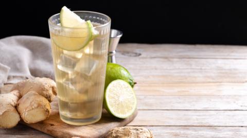 Fresh ginger ale drink in tall glass on wooden table