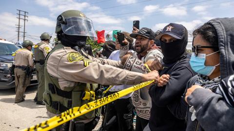 Un agente del sheriff del condado de Los Ángeles contiene a manifestantes luego de múltiples detenciones por parte de ICE) en la ciudad de Paramount.