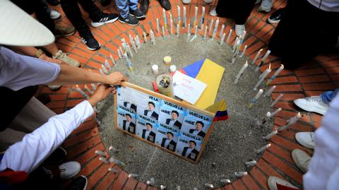 Personas encienden velas durante una protesta contra la violencia y a favor de la paz en Medellín, Colombia.
