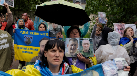 Familiares y amigos sostienen fotografías de sus seres queridos durante un intercambio de prisioneros de guerra en un lugar no revelado en Ucrania el 12 de junio de 2025, en medio de la invasión rusa de Ucrania.