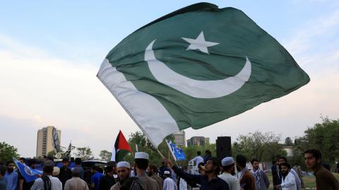 Un hombre ondea una bandera pakistaní, un día después del anuncio del alto el fuego entre India y Pakistán.