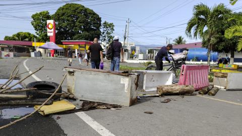 Personas pasan junto a un bloqueo vial en Changuinola, Bocas del Toro, Panamá.
