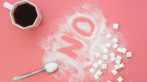 Word No made of sugar and cup of coffee on pink background, flat lay, diabetes problems, harm from eating, dependence on flavoring.