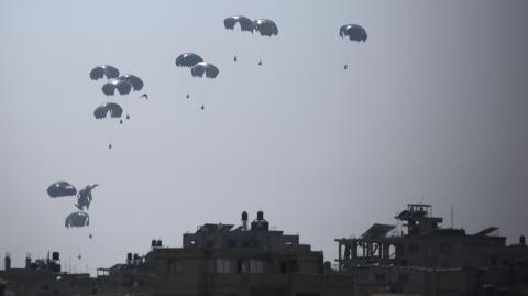 Un avión de transporte militar lanza ayuda humanitaria sobre Al-Zawayda, en el centro de la Franja de Gaza.