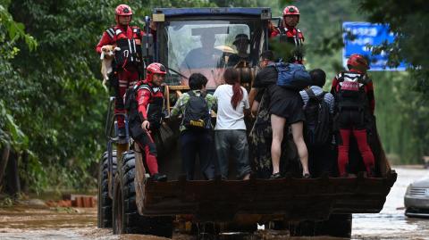 El equipo de rescate evacuó a residentes de su hogar en una carretera inundada tras las fuertes lluvias en la aldea de Taishitun.