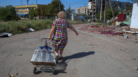 Una residente tira de un carrito con botellas de agua en una calle en la ciudad de primera línea de Kostiantynivka, en medio del ataque de Rusia a Ucrania, en la región de Donetsk, Ucrania, el 6 de agosto de 2025.